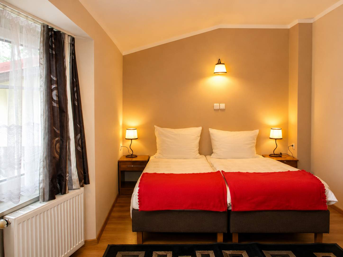 Przytulny pokój hotelowy z drewnianymi meblami i miękkim porannym światłem w Hotelu Pod Platanami
